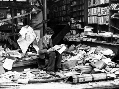 Jovem lê livro de história livraria de Londres, destruída após bombardeio